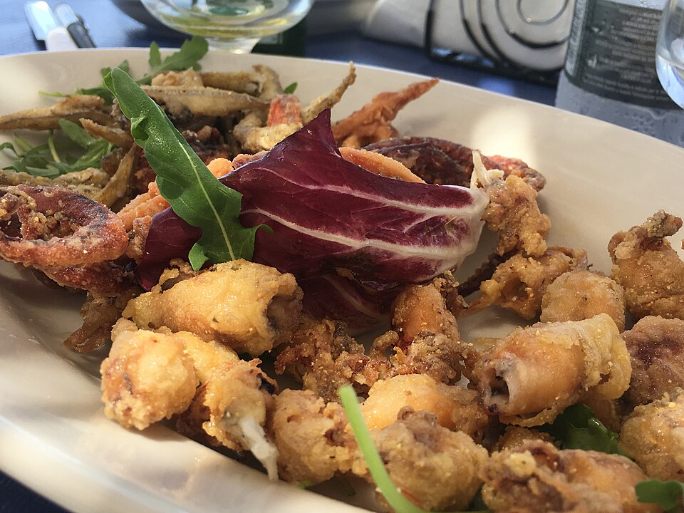 Teller mit knusprig frittierten Meeresfrüchten, garniert mit Radicchio und Rucola