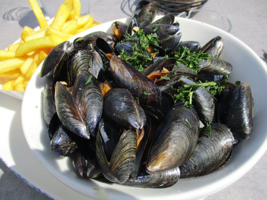 Schüssel mit gedämpften Miesmuscheln und Pommes frites