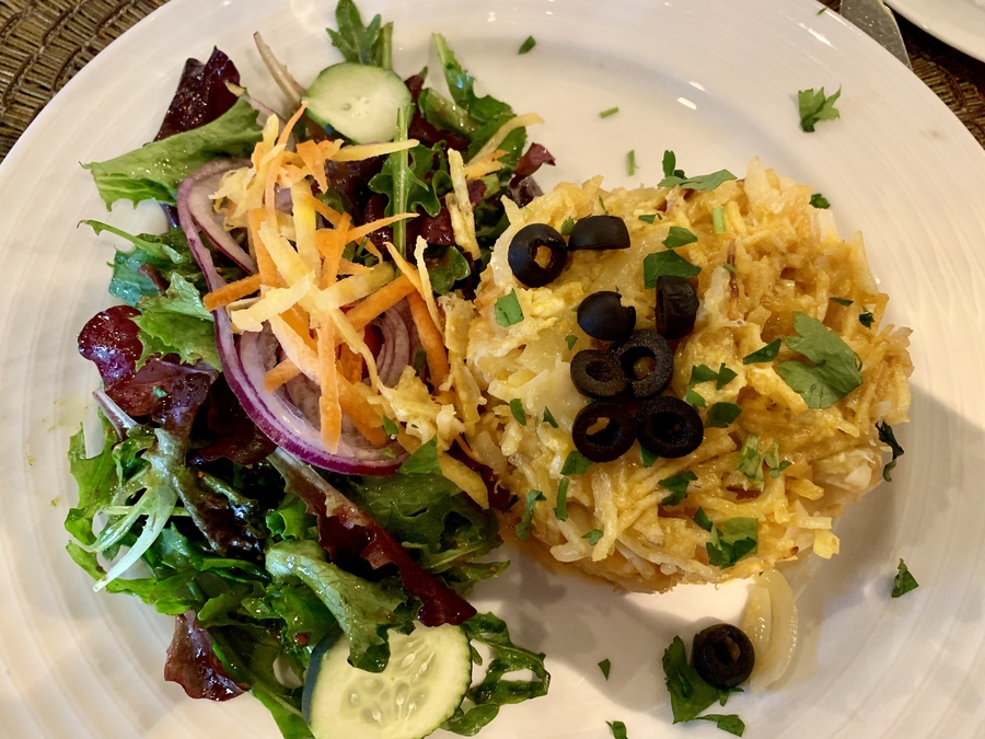 Teller mit Bacalhau à Brás, garniert mit schwarzen Oliven
