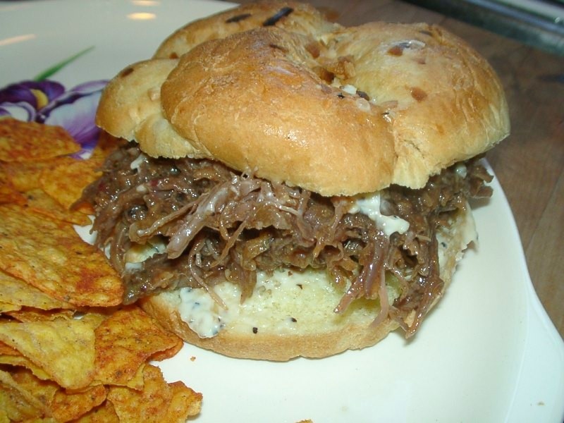 Zerzupftes geräuchertes Schweinefleisch (Pulled Pork) auf einem Brötchen mit Krautsalat