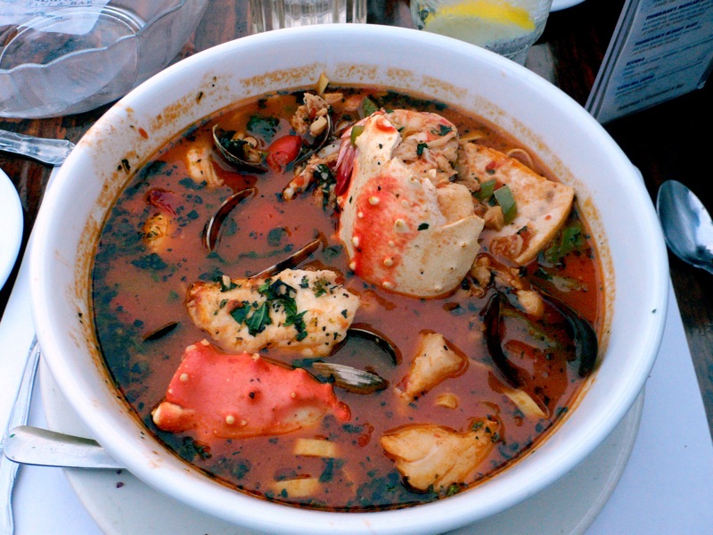 Schüssel Cioppino mit Muscheln, Krabbenbeinen, Fisch und Tomatensud