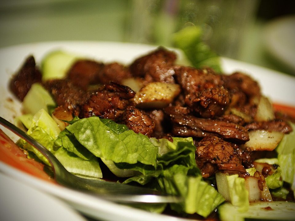 Gebratene Rinderwürfel auf Salat und Gurke