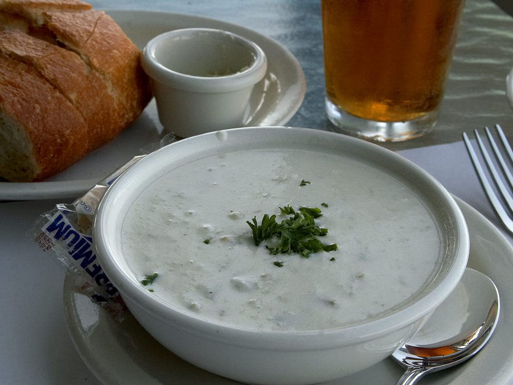 Schale Clam Chowder mit Kräutern, daneben Cracker