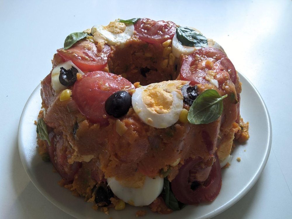 Gestürzter Cuscuz paulista mit Ei, Tomate und Oliven