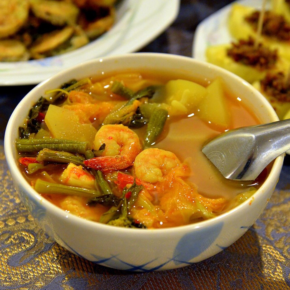 Gaeng Som mit Garnelen und Gemüse in einer Schale