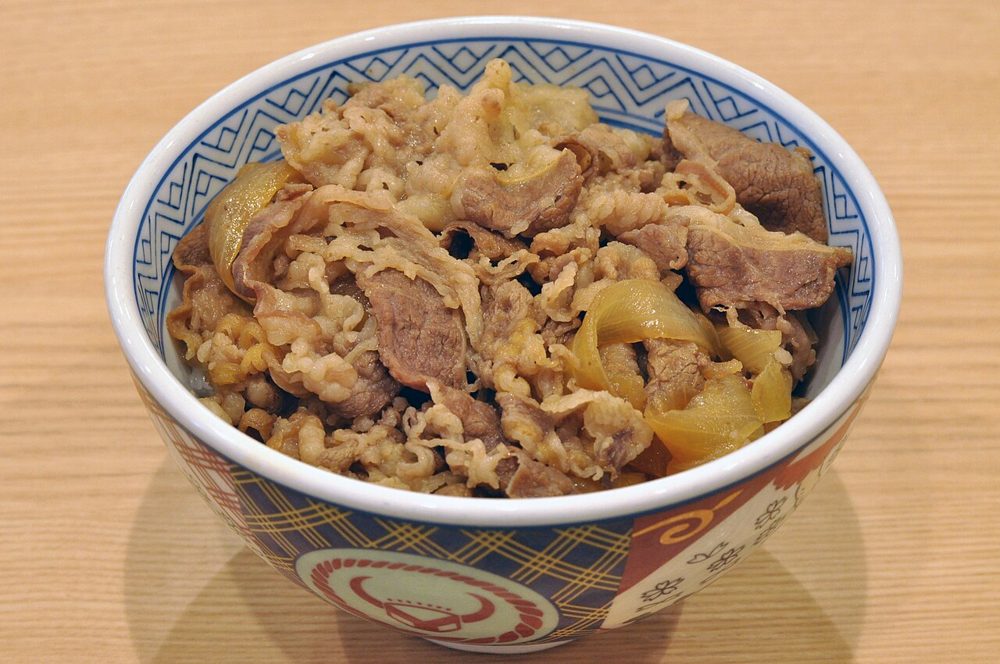 Schale Reis mit dünn geschnittenem Rindfleisch und Zwiebeln