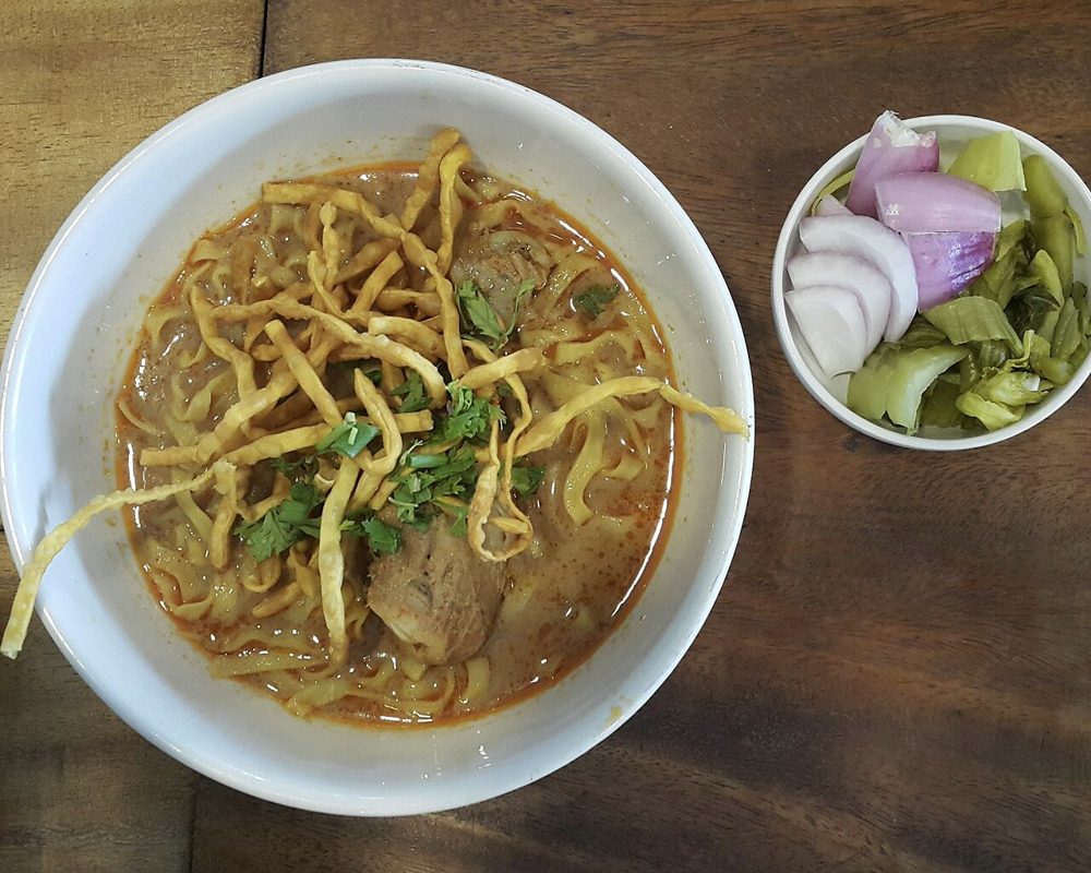 Khao Soi mit knusprigen Nudeln und Beilagen