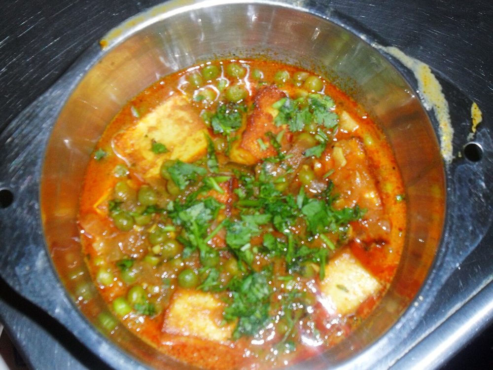 Matar Paneer mit Erbsen und Koriander in einer Metallschale