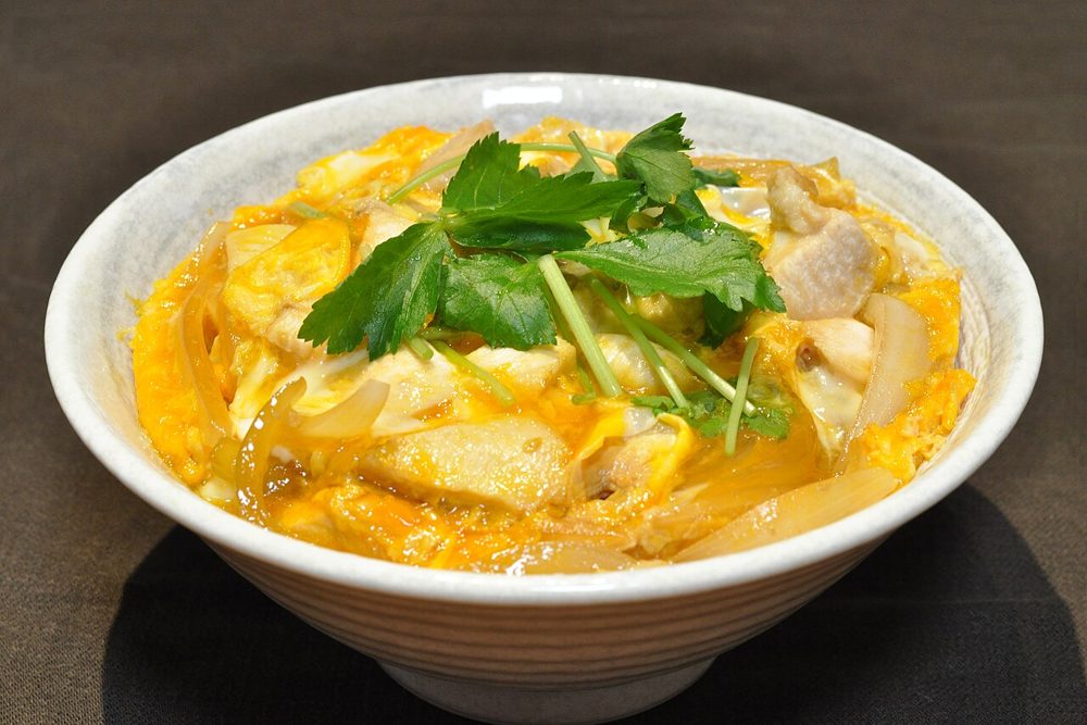 Reisschale mit Hähnchen in zartem Ei