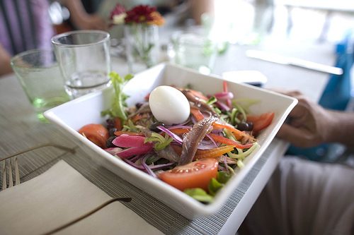 Salade niçoise mit Ei, Tomaten und Salat in einer Schale