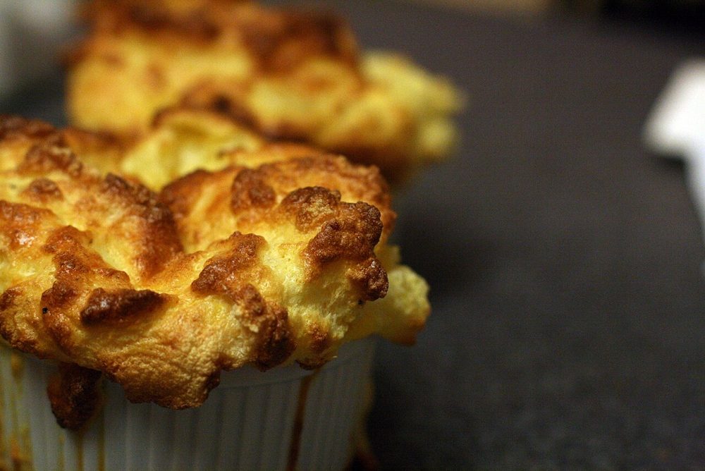 Goldbraun aufgegangenes Käsesoufflé im Förmchen
