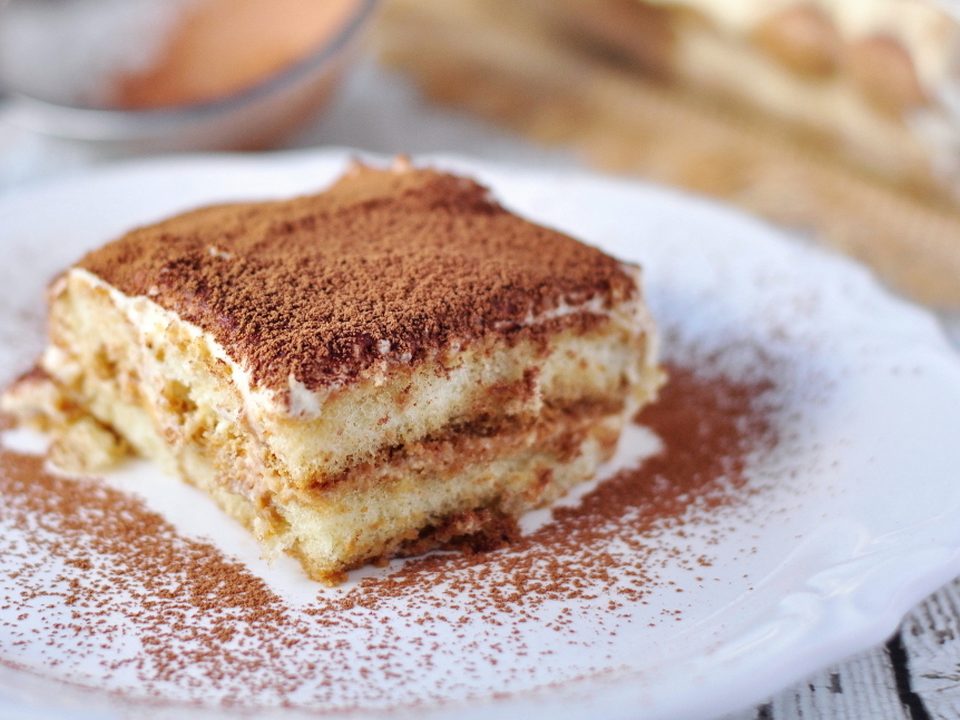 Stück Tiramisù mit Kakaopulver bestäubt auf einem Teller