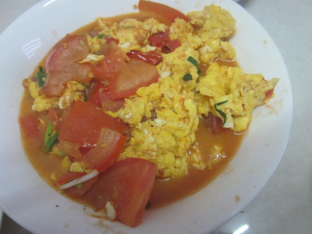 Teller mit pfannengerührten Tomaten und Rührei