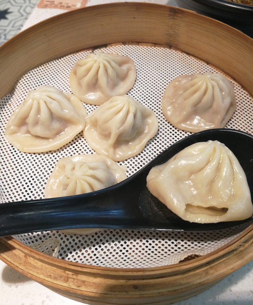 Gedämpfte Xiaolongbao im Bambuskorb mit Löffel